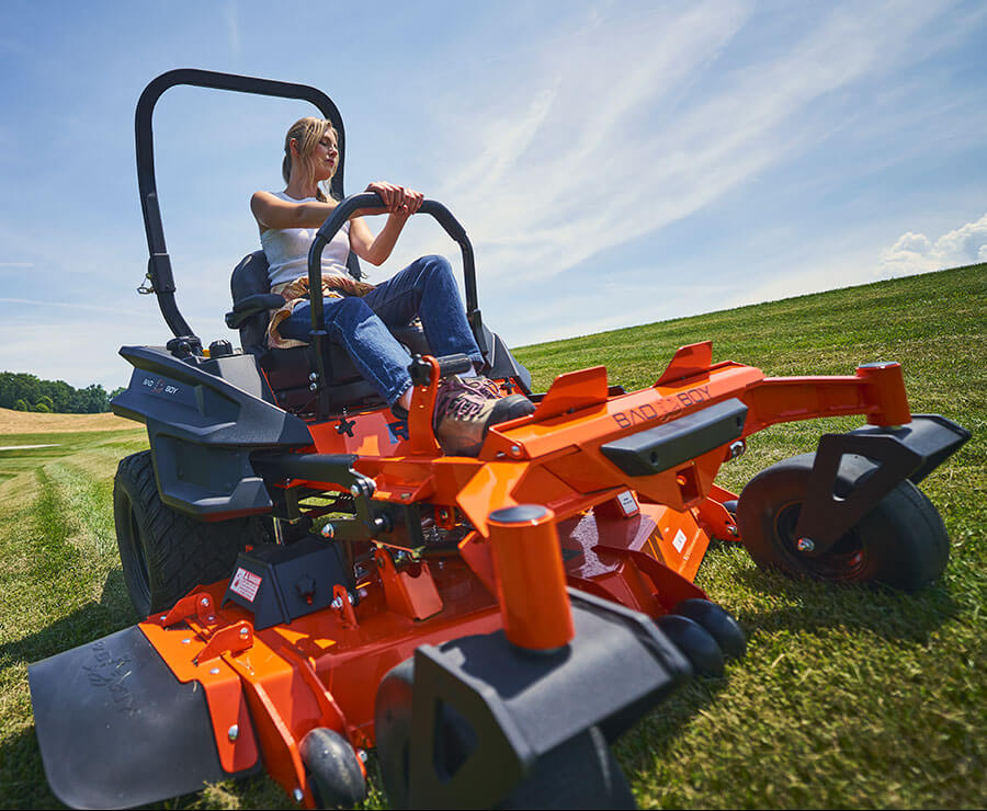 Operator mowing open acreage with a Bad Boy zero-turn riding mower.