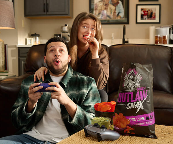 Outlaw Snax Chili Lime Blaze flavored tortilla chips enjoyed during a casual video game night at home.