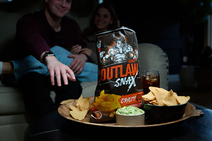 Outlaw Snax Crazy Queso flavored tortilla chips served with queso dip during a family movie night.